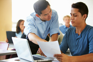 High School Students With Teacher In Class Using Laptops