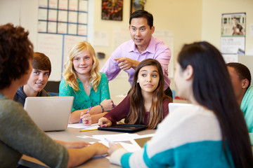 High School Students With Teacher In Class Using Laptops - obrazy, fototapety, plakaty