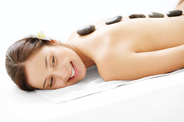 Beautiful Woman Getting Spa Hot Stones Massage in Spa Salon.