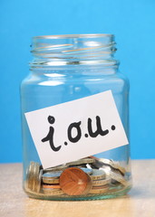 I.O.U Money concept with coins in a glass jar