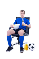 young supporter in football form sitting with ball, chips and bo