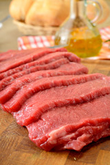 Fettine di carne di manzo crude sul tagliere di legno