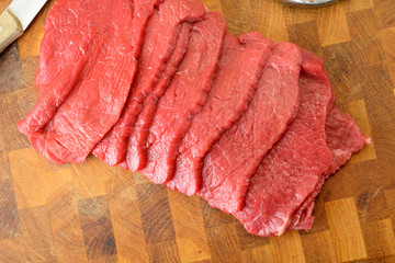 Fettine di carne di manzo crude sul tagliere di legno