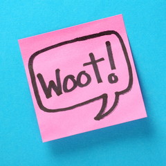 The word Woot! written in a speech bubble on a pink sticky note