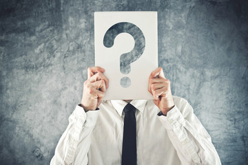 Businessman holding paper with printed question mark
