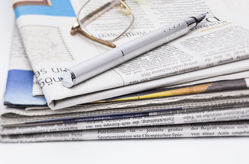 Zeitungsstapel Brille und Blog