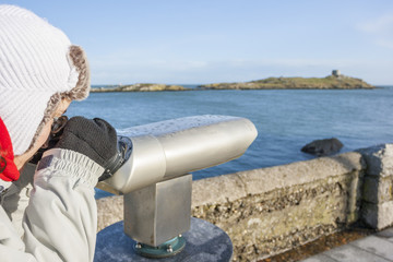woman looking to Dalkey island by binoculars