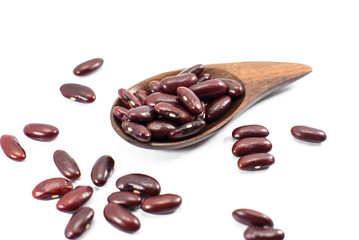 Dried red beans on a wooden spoon with a shallow depth of field