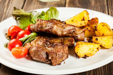 Grilled steaks, baked potatoes and vegetables