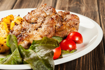 Grilled steaks, baked potatoes and vegetables