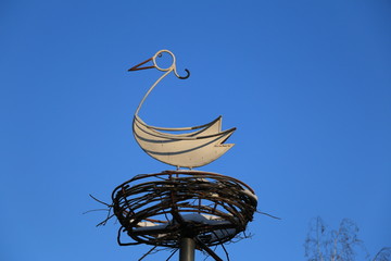 Железный аист в гнезде на фоне неба