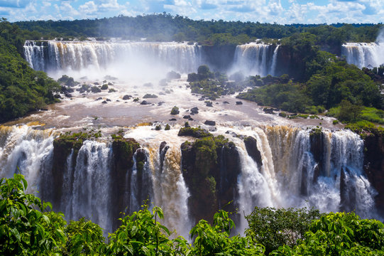 Beautiful Cascade of waterfalls with clouds and jungle. Iguassu