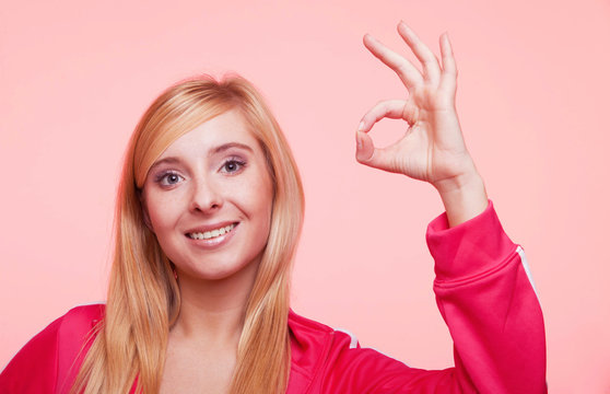 sporty fit woman showing ok sign hand gesture