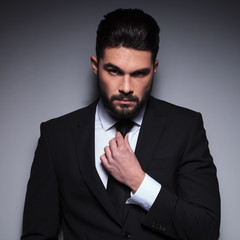 young fashion man fixes his tie