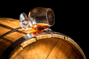 Glass of cognac on the vintage barrel - obrazy, fototapety, plakaty