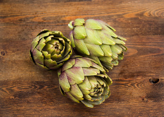 Obraz premium Raw Artichokes on dark wood