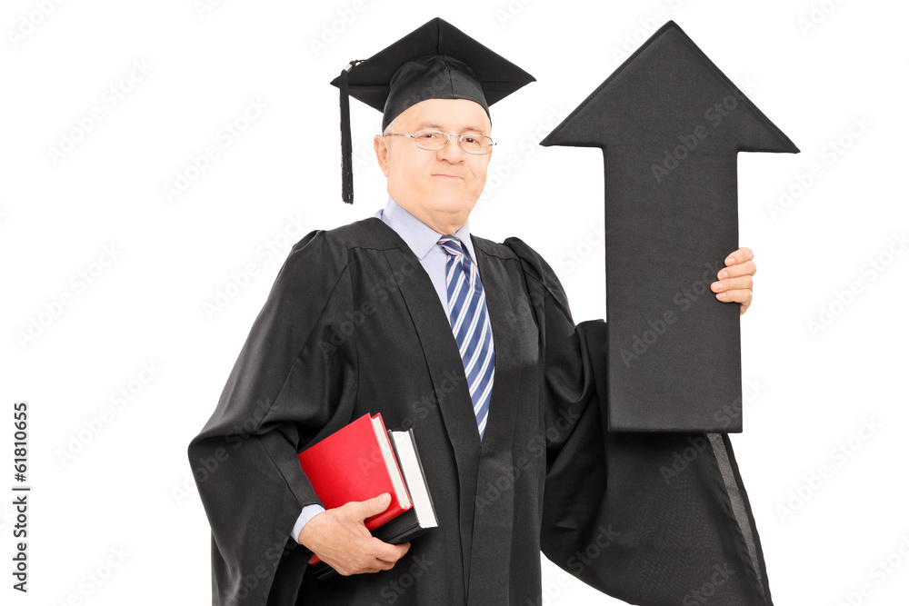 Wall mural Mature man in graduation gown holding arrow pointing up