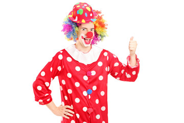 Smiling happy clown in red costume giving thumb up