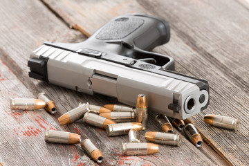 Handgun with scattered bullets and cartridges