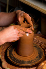 hands of a potter, creating an earthen jar
