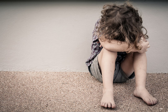 Sad Little Boy Sitting On The Road