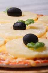 Pizza with pineapple and black olives macro. Vertical