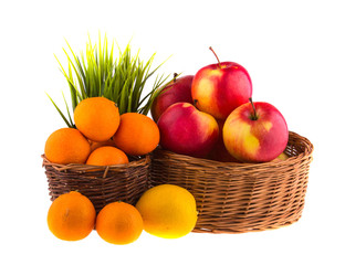 Red and yellow apples, tangerines and lemons in a wooden basket.