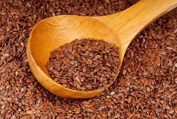 close up of flax seeds and wooden spoon as  food background