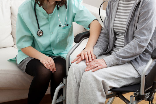 Doctor supporting disabled elderly