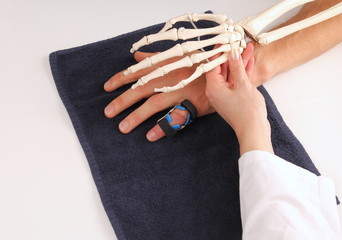 Handchirurg mit Skeletthand bei Patienten nach OP