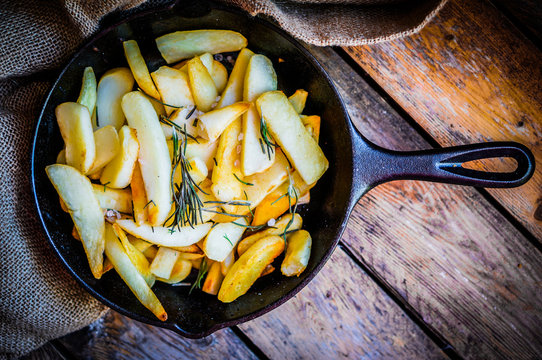 Homemade french fries with rosemary and salt in cast iron skille