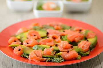 Piatto di avocado e salmone affumicato in insalata