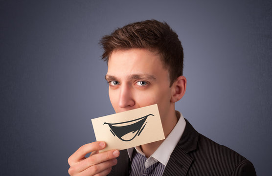 Happy businessman holding funny white card on his mouth