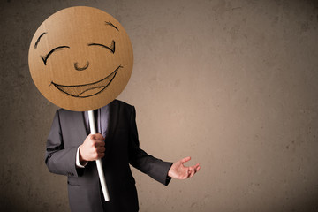 Businessman holding a smiley face board