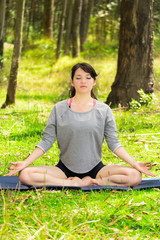 Pretty woman doing yoga exercises in the park