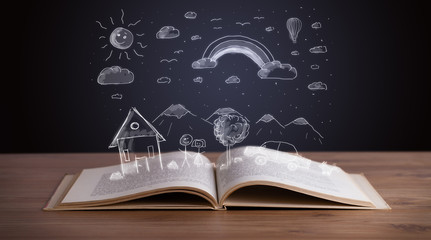 Open book with hand drawn landscape