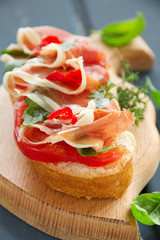Bruschetta with prosciutto, tomato and basil.