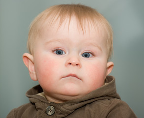Serious boy with big grey eyes portrait  on a grey background - 61834645