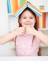 Little girl is reading a book