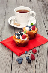 Tasty cupcakes with berries on wooden table