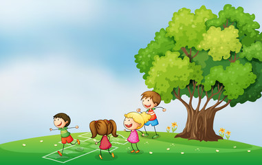 Obraz na płótnie Canvas Kids playing at the hilltop near the tree