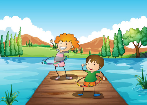 Two kids playing hulahoop at the river