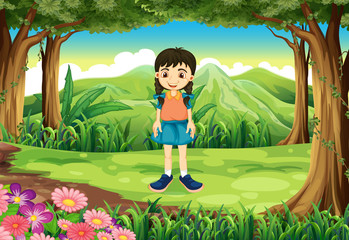 Obraz na płótnie Canvas A cute young girl standing near the trees