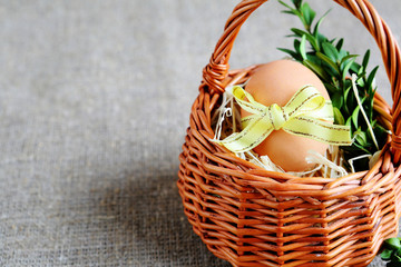 Fototapeta na wymiar Easter egg with yellow ribbon in a basket