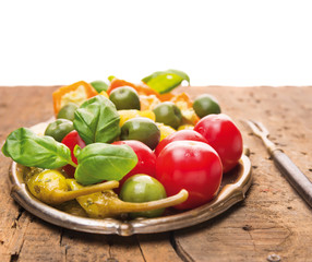 Italian antipasti vegetables with basil on old wooden table
