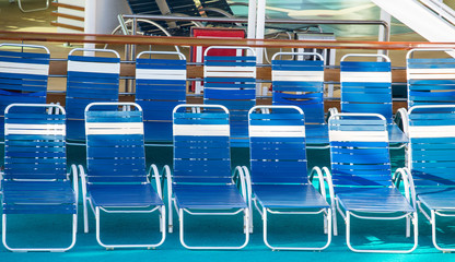 Fototapeta premium Blue and White Vinyl Chaise Lounges on Cruise Ship Deck