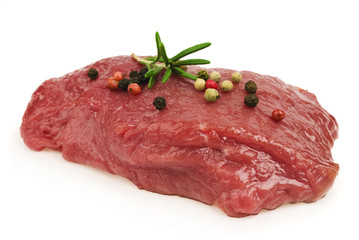 Raw ribeye steak garnished with a sprig of rosemary.