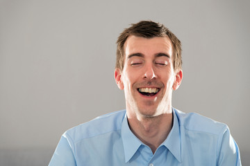 Mimik, Gesicht, junger Mann, blaues Hemd, kurze, dunkle Haare