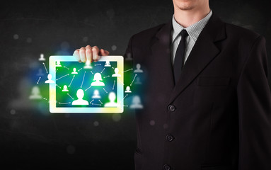 Young person presenting tablet with green social media icons