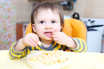 little boy eating corn curls © ivolodina